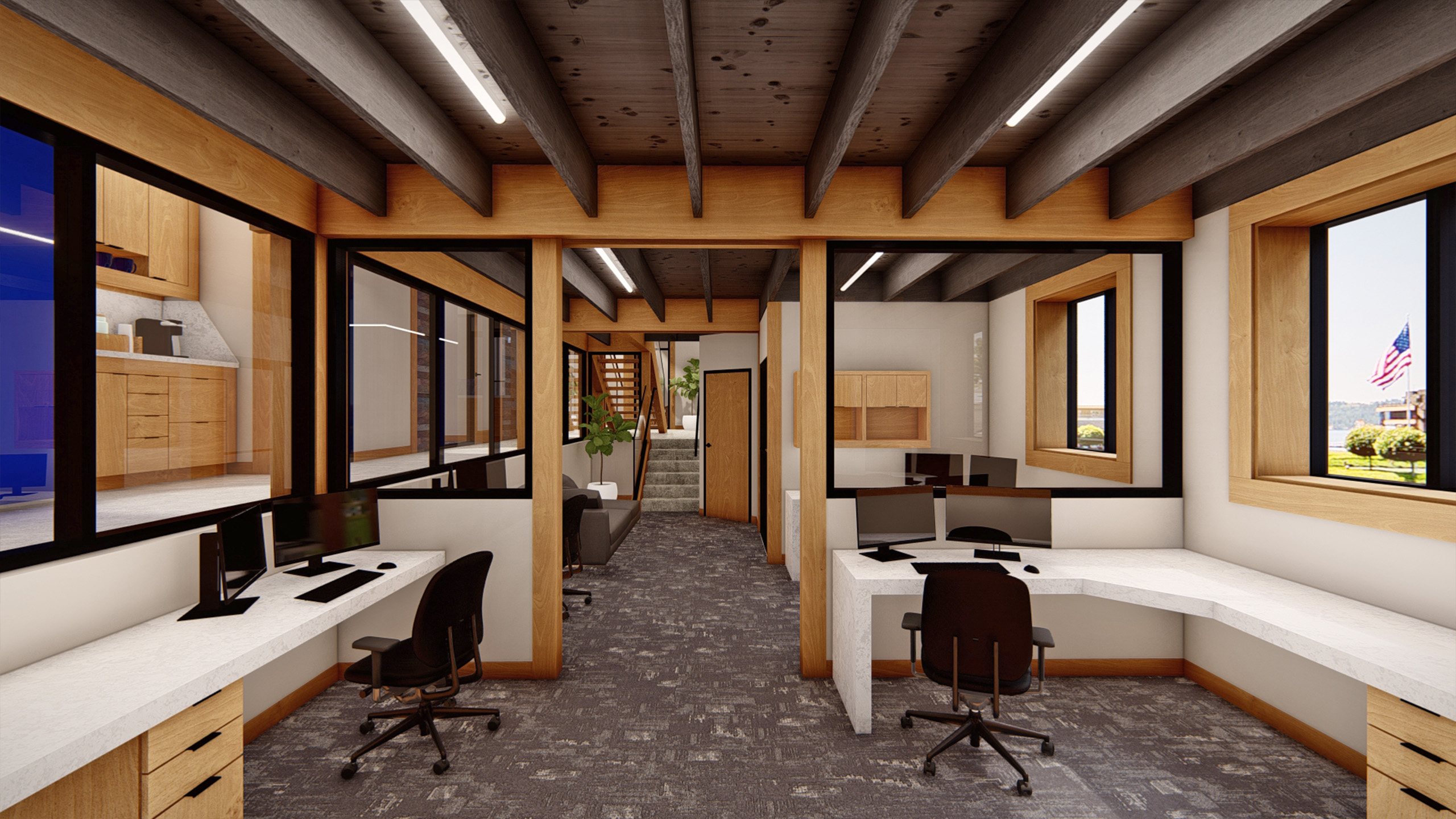 Modern office interior at Coldwell Banker in The Shops, Coeur d'Alene, Idaho, featuring built-in white desks, wood trim, exposed ceiling joists, and large windows with views of a flag and landscape outside.