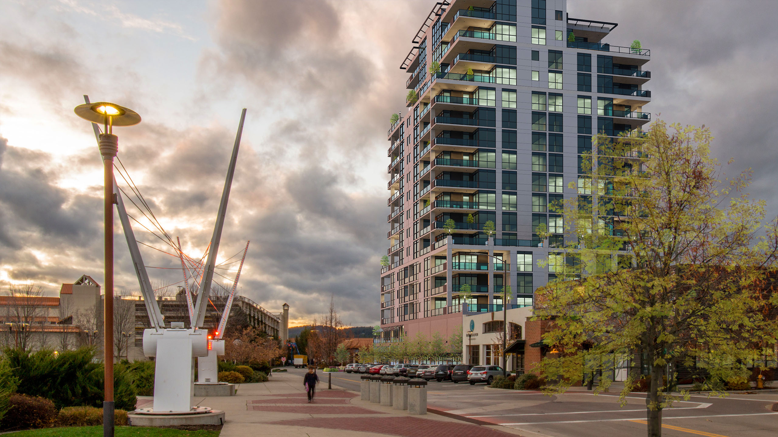 Street-level view of The Thomas George in downtown Coeur d’Alene, showing high-rise architecture, public art, and pedestrian-friendly urban design.